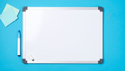 White board with marker pen and scratch paper isolated on blue paper background, top