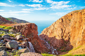 Obraz premium Battery waterfall on the shore of the Barents Sea. Teriberka, Kola Peninsula, Russia.