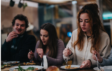 A group of friends enjoying dinner together in a cozy and casual restaurant environment.