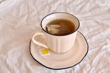 Chamomile tea bag brewing in a cup. Concept of natural healing, relaxation, and herbal medicine.

