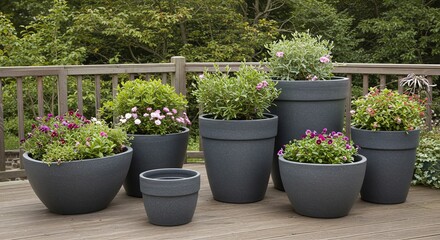 Assorted Gray Planters with Blooming Flowers on a Wooden Deck Against a Green Forest Backdrop