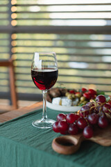 A glass of red wine with antipasto on the terrace table.