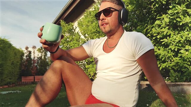 Man Holding Mug on Garden Grass at Sunset