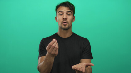 Young hispanic man gesturing for money over an isolated green background, emphasizing his...