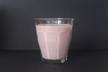 strawwberry milk inside glass cup with black background