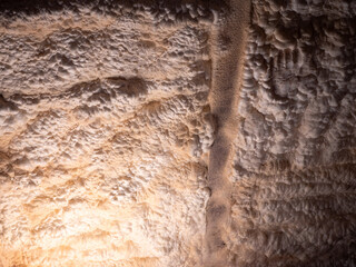 Close-up of polyurethane foam insulation applied to wooden ceiling structure in attic, showing...