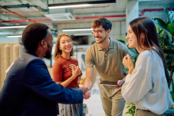Business partners shaking hands after signing a contract in a modern office, celebrating successful deal