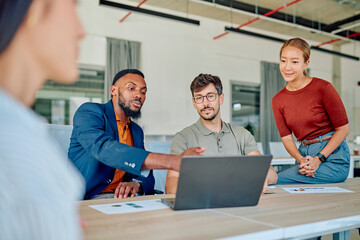Diverse colleagues working together analyzing data on laptop, collaborating on project in workplace, teamwork and cooperation concept
