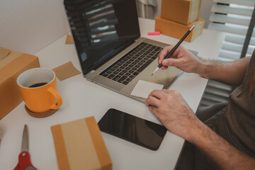 an entrepreneur has his own small online business, the business owner checks the package before...