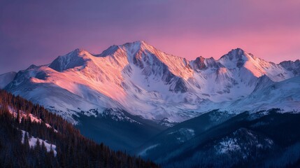 pink alpenglow illuminating snowy mountain peaks at dawn in serene light