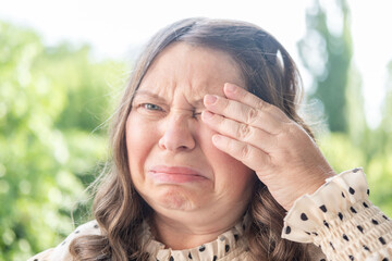 Upset 50-year-old woman with tears streaming down face, emotional portrait, deep despair, crying intensely. Emotional pain, grief, and loss, close-up face middle-aged woman, stress relief