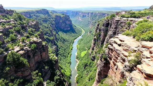Aerial view of mountain peaks and valleys from the top A view from a cliff edge overlooking a deep valley with a winding river below  high quality videos footages