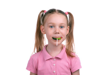  Smiling young girl with pigtails holding a green lollipop in her mouth, standing against a clean white background.