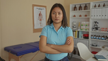 Woman in blue shirt stands confidently in a hospital room, showcasing a clinical setting with...