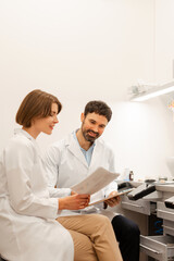 Two medical people reading medical records in modern clinic