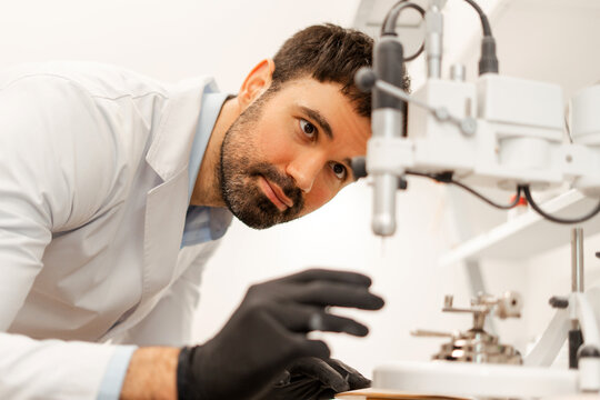 Scientist carefully operating precision machinery in laboratory