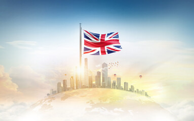 Naklejka premium United Kingdom flag wavering on globe with modern building skyline. Flag waving on world map. UK national flag for independence day.