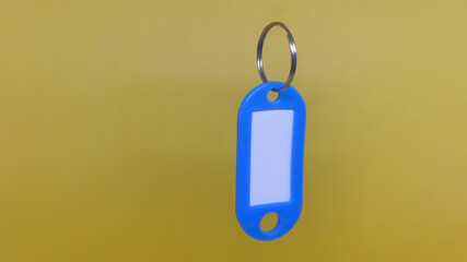 Blue Key Tag on Yellow Backdrop.