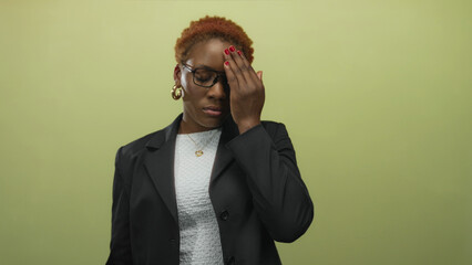 Young african american woman with black blazer and white top wearing glasses and gold hoop earring...