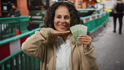 Woman holding romanian lei smiles on a busy city street, showcasing cheerful expression with...