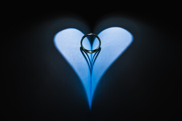 Engagement ring with a shadow background that projects a heart with a black background
