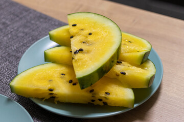 Close up shot of the cut watermelon with yellow flesh on ceramic plate. Food