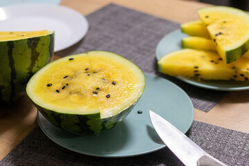 Close up shot of the cut watermelon with yellow flesh on ceramic plate. Food