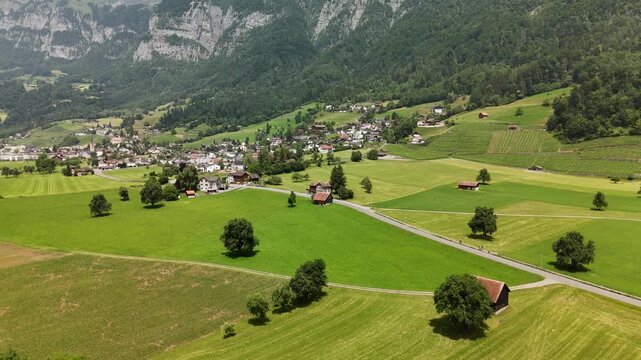 Scenic Aerial View of a Valley with Green Fields and Mountain Landscape in Switzerland near Flums, Berschis, and Walenstadt in the Canton of St. Gallen &ndash; Drone Footage