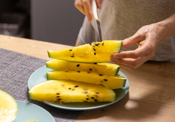Person cuts watermelon with yellow flesh. Food