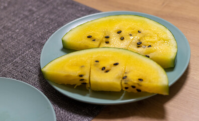 Close up shot of the cut watermelon with yellow flesh on ceramic plate. Food