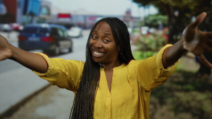 Woman hugging herself joyfully on a city street, capturing the essence of urban life with her bright yellow attire and relaxed demeanor.