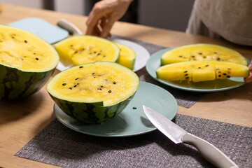 Close up shot of the cut watermelon with yellow flesh on ceramic plate. Food