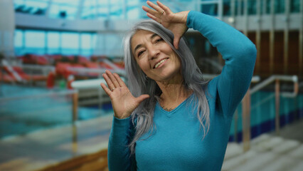 Senior woman with grey hair enjoys a cruise on a boat at the seaside, showcasing joyful expressions in an outdoor setting with a vibrant background.