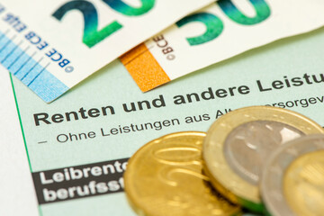 Euro Banknoten und Münzen liegen auf einem Steuerformular für Renten