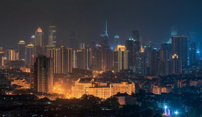 Fototapeta premium Illuminated cityscape at night with tall buildings and glowing lights