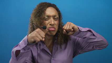 Hispanic transgender woman pouts with clenched fists, tears and headset microphone in studio;...