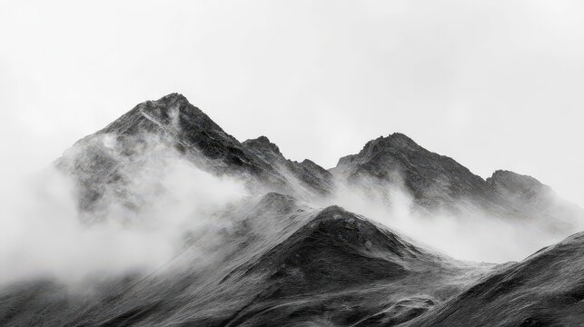 Dramatic black and white mountain peaks shrouded in thick fog, creating a moody and atmospheric alpine landscape.
