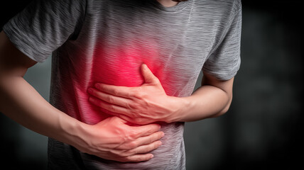 Man clutching his abdomen with a red illuminated area visualizing acute stomach pain and digestive disorder, conveying urgency of diagnosis treatment and awareness of gastrointestinal health issues.
