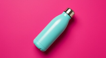 Vibrant still life featuring a reusable turquoise water bottle with a sleek silver cap, set against a bold and striking pink background.