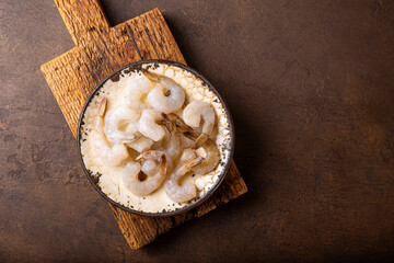  Raw shrimps in a plate on the dark background top view