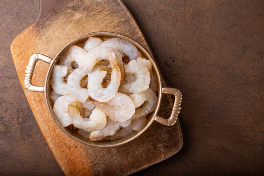  Raw shrimps in a pan on the dark background top view copy space for text