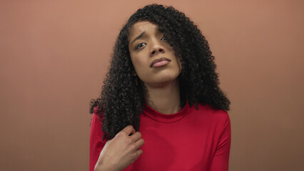 Woman palm up gesture asking money while wearing red top with open hand in studio with peach...