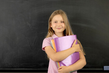 Smiling student girl holding notebooks