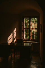 Warm light through old wooden windows, cozy interior with sunlight and architectural charm.