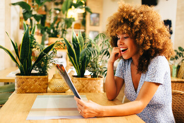 Excited customer reading menu in cozy restaurant with plants