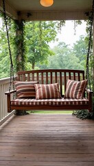 Cozy wooden swing with striped cushions on a porch surrounded by greenery