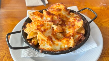 Hot Cheesy Potato Wedges Fresh from the Oven Served in a Rustic Pan on Wooden Table