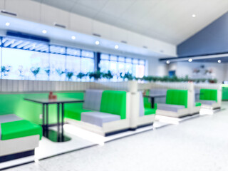 Empty, blurred, modern restaurant booths with bright green seats