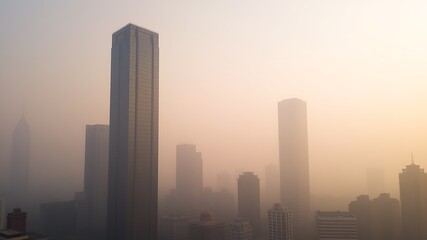 Fototapeta premium Illustration of skyscrapers shrouded in thick fog and smog create a dramatic urban landscape, highlighting the severity of air pollution