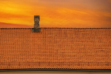 Orange clay tile roof. Clay tile roof with orange sky at sunset